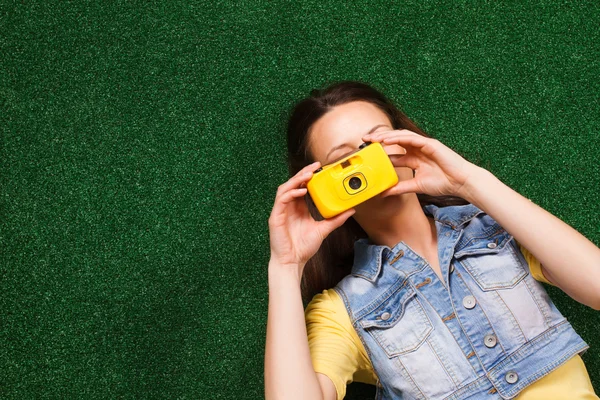 Kvinnan ligger på gräset med kamera — Stockfoto