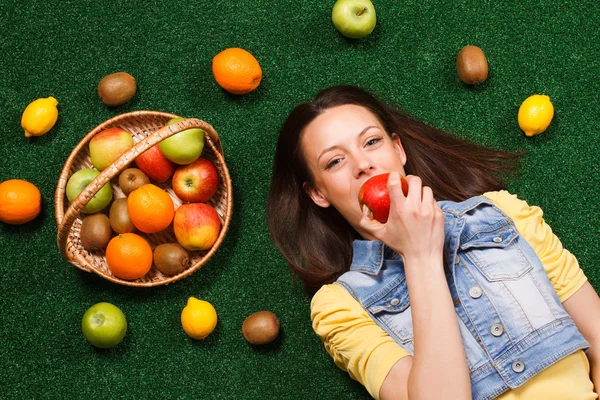 Woman eten apple op gras — Stockfoto