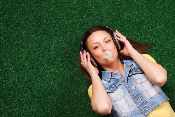 Vrouw zeepbel blazen en muziek luisteren — Stockfoto