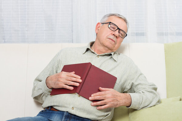 old man sleeping with book