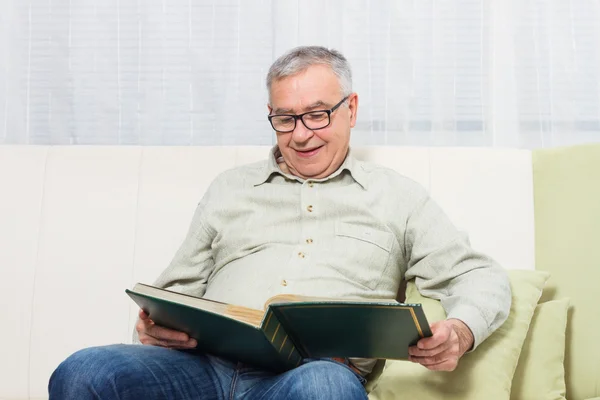 Viejo hombre viendo foto álbum — Foto de Stock