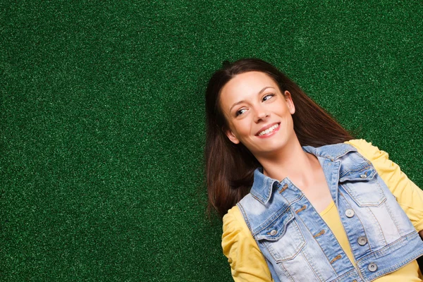 Thinking woman lying on grass — Stock Photo, Image