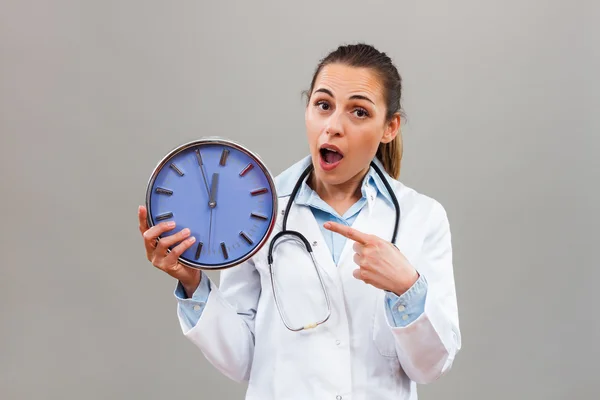 Medico donna indicando orologio — Foto Stock