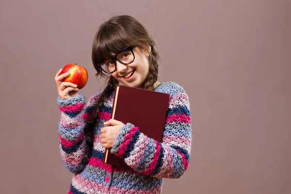 Nörd flicka med bok och äpple — Stockfoto