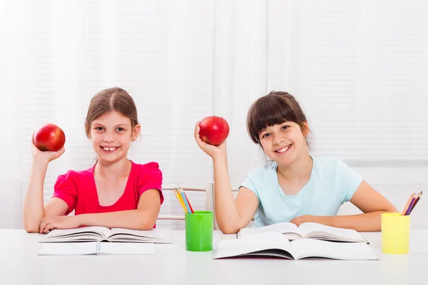 Zwei glückliche Schulmädchen mit Apfel — Stockfoto