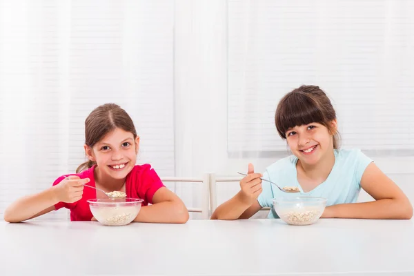 Meninas comendo cereais no café da manhã — Fotografia de Stock