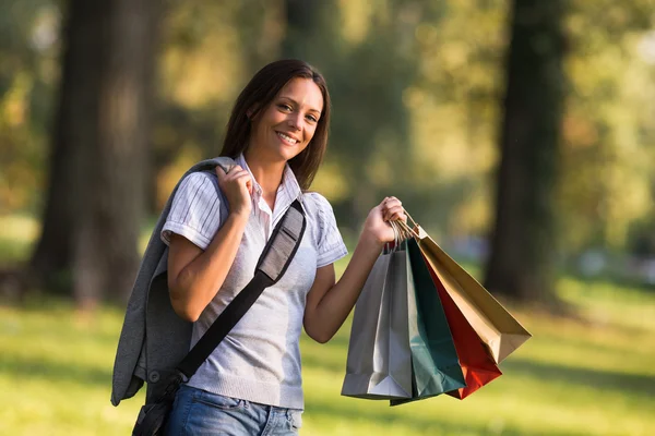 Businesswoman after shopping in park — Stock Photo, Image