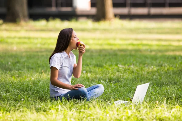 Geschäftsfrau isst Apfel im Park — Stockfoto