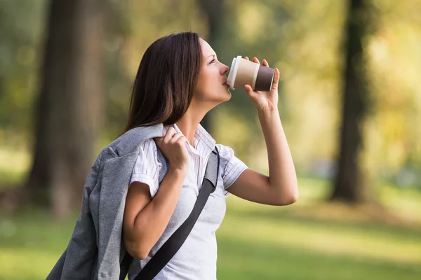 Kobieta pije kawę w parku — Zdjęcie stockowe