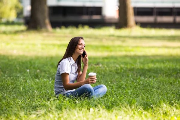 Geschäftsfrau trinkt Kaffee im Park — Stockfoto