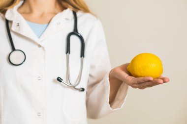 Limon gösteren kadın doktor görüntüsü.