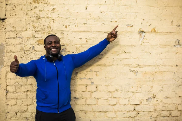 Portrait Sporty Man Showing Thumb Pointing While Standing Front Wall — Stok fotoğraf