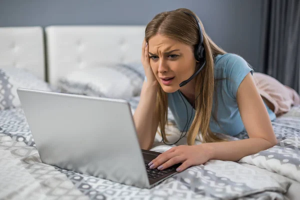 Mujer Trastornada Con Auriculares Usando Portátil Dormitorio —  Fotos de Stock