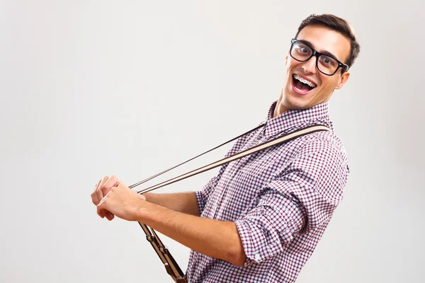 Guapo empollón tirando de sus tirantes . — Foto de Stock