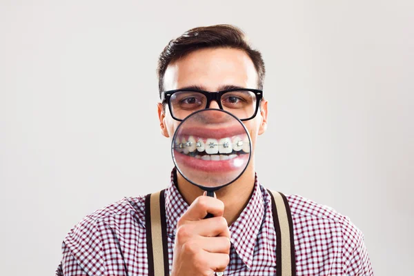 Nerdy man toont zijn tanden met accolades Stockfoto