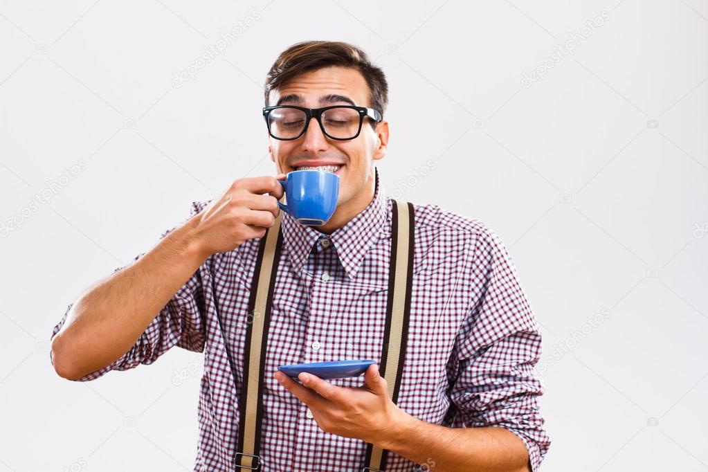 Nerd guy enjoys drinking coffee