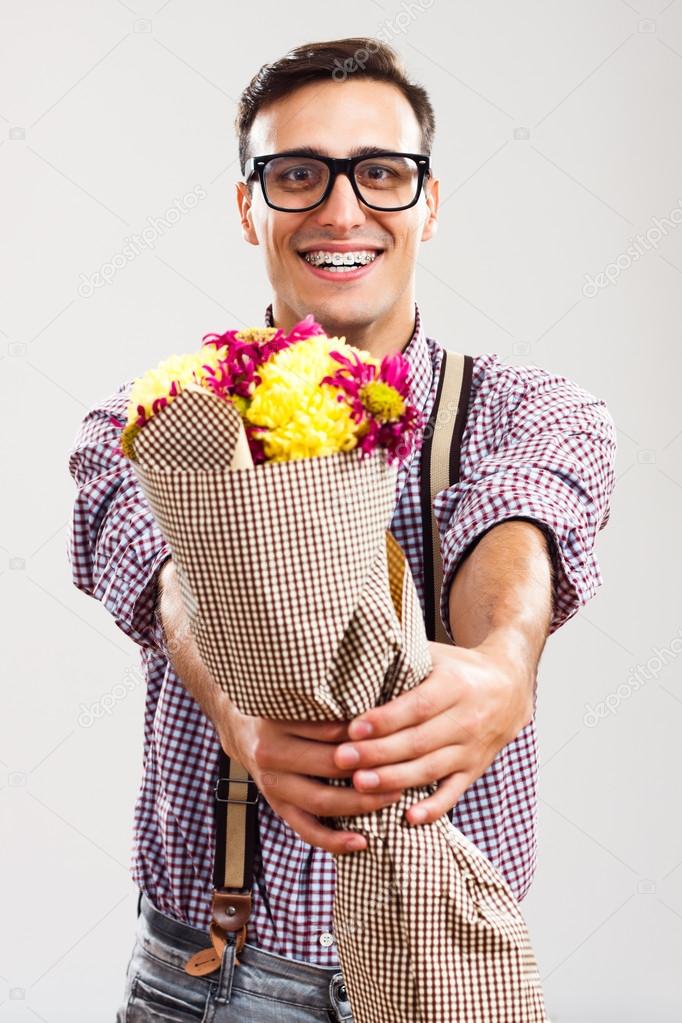 Nerdy man is giving a bouquet of flowers