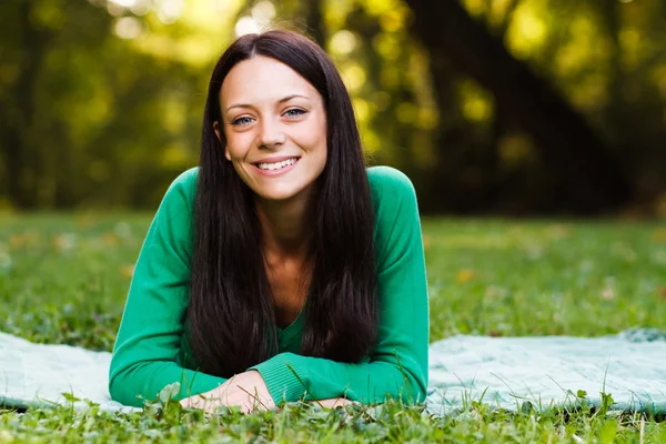 Woman lying down in nature and looking at camera — Stock Photo, Image