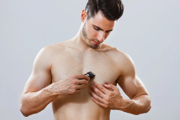 Красивый мужчина бреет грудь — стоковое фото