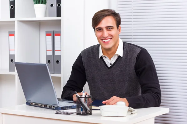 Zakenman zitten in zijn kantoor en werken op zijn laptop — Stockfoto