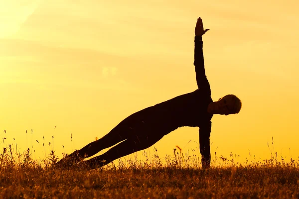 Vrouw praktizerende yoga, zijkant plank vormen — Stockfoto