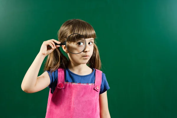 Carino bambina tenendo lente d'ingrandimento — Foto Stock