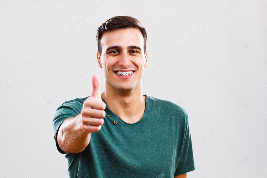 Man with braces showing thumbs up