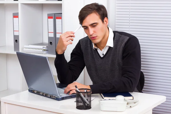 Empresario en su oficina, trabajando en su portátil y pensando — Foto de Stock