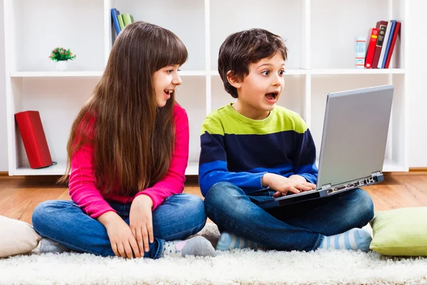 Schattig klein meisje en kleine jongen laptop gebruikt — Stockfoto