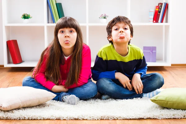 Kleine jongen en meisje hun tong uitsteekt — Stockfoto