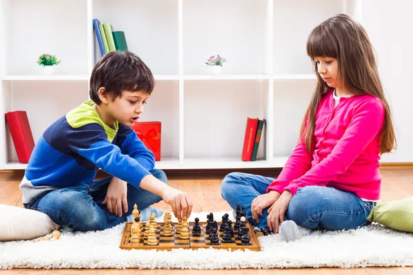 Petit garçon et petite fille jouent aux échecs — Photo