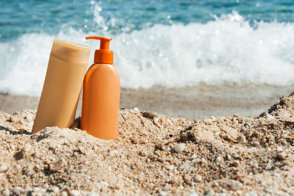 Botellas de loción bronceadora en la playa, Protección solar — Foto de Stock