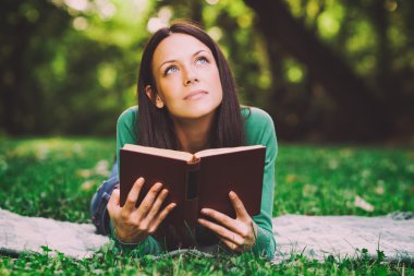 Kadın bir şey hakkında bir kitap okurken düşünüyor