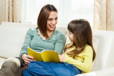 Anne kızı ödevlerinde yardımcı olur