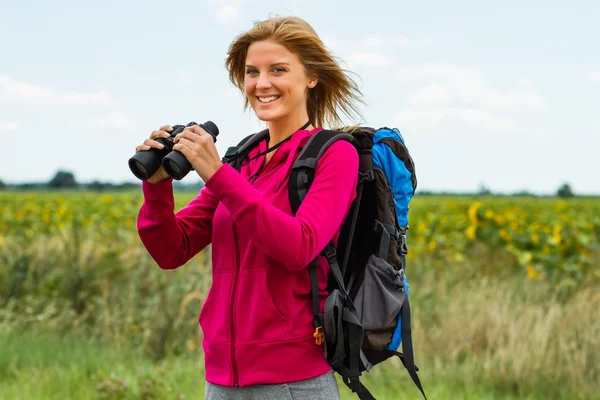 Woman holding binoculars — Stock Photo, Image