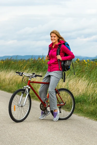 Woman with a bike on nature — Stock Photo, Image