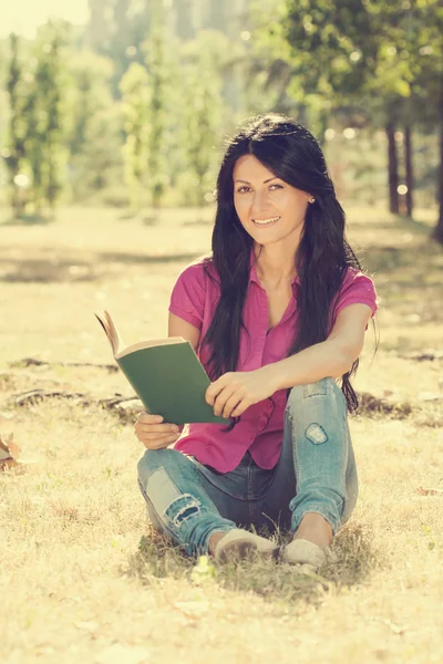 Kvinna läser en bok och njuta av på fritiden — Stockfoto