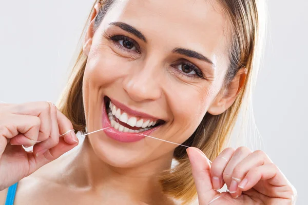 Hermosa mujer usando hilo dental . — Foto de Stock