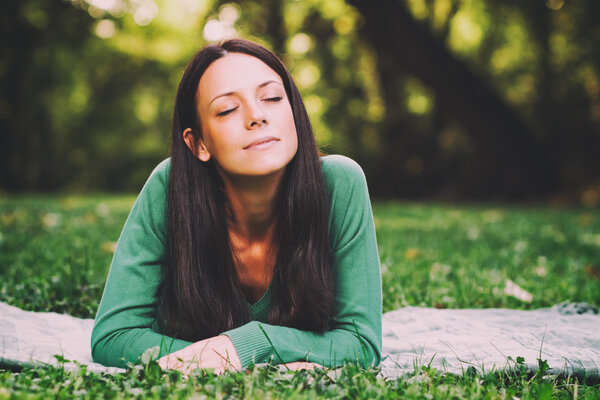 Woman lying down in nature and thinking about something