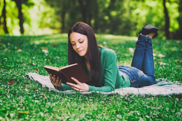 Mulher está pensando em algo enquanto lê um livro — Fotografia de Stock