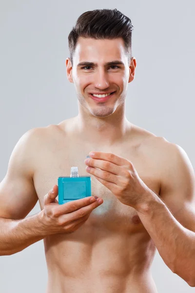 Porträtt av stilig man håller aftershave — Stockfoto