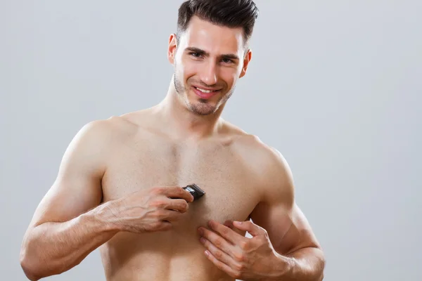 Красивый мужчина бреет грудь — стоковое фото