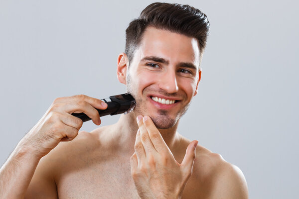 Portrait of handsome man shaving