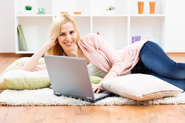 Donna che utilizza il computer portatile a casa sua — Foto Stock