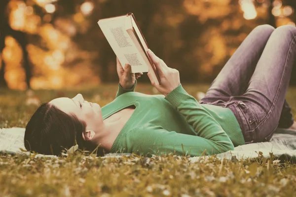 Vrouw is lezen van een boek en in haar vrije tijd geniet Stockafbeelding