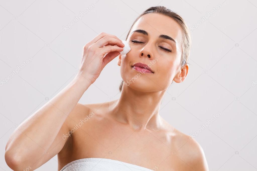 Woman is cleaning her face