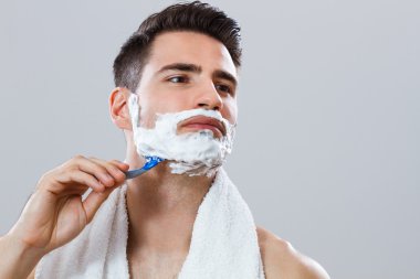 Photo of handsome man shaving his face clipart
