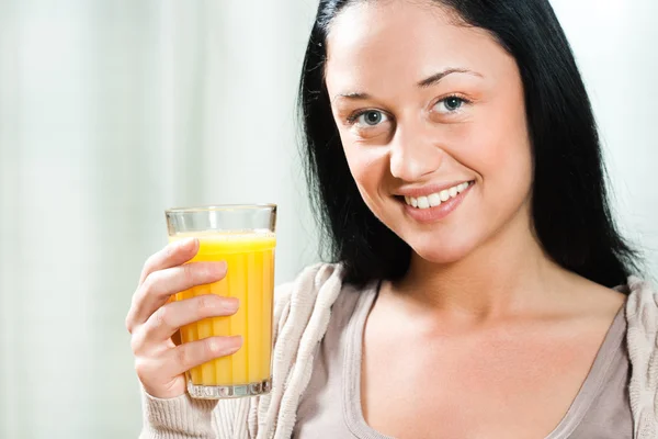 Oung woman holding glass of orange juice — Stock Photo, Image