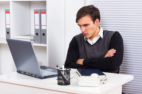 Homem de negócios está com raiva por causa de algo que ele vê em seu monitor laptop — Fotografia de Stock