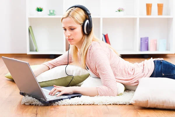 Mulher usando laptop em sua casa — Fotografia de Stock